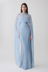 Woman wearing a light blue chiffon overlay maxi dress.