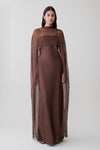 Woman wearing a brown chiffon overlay maxi dress.