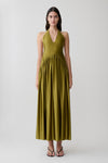 Woman wearing a green halter maxi dress.
