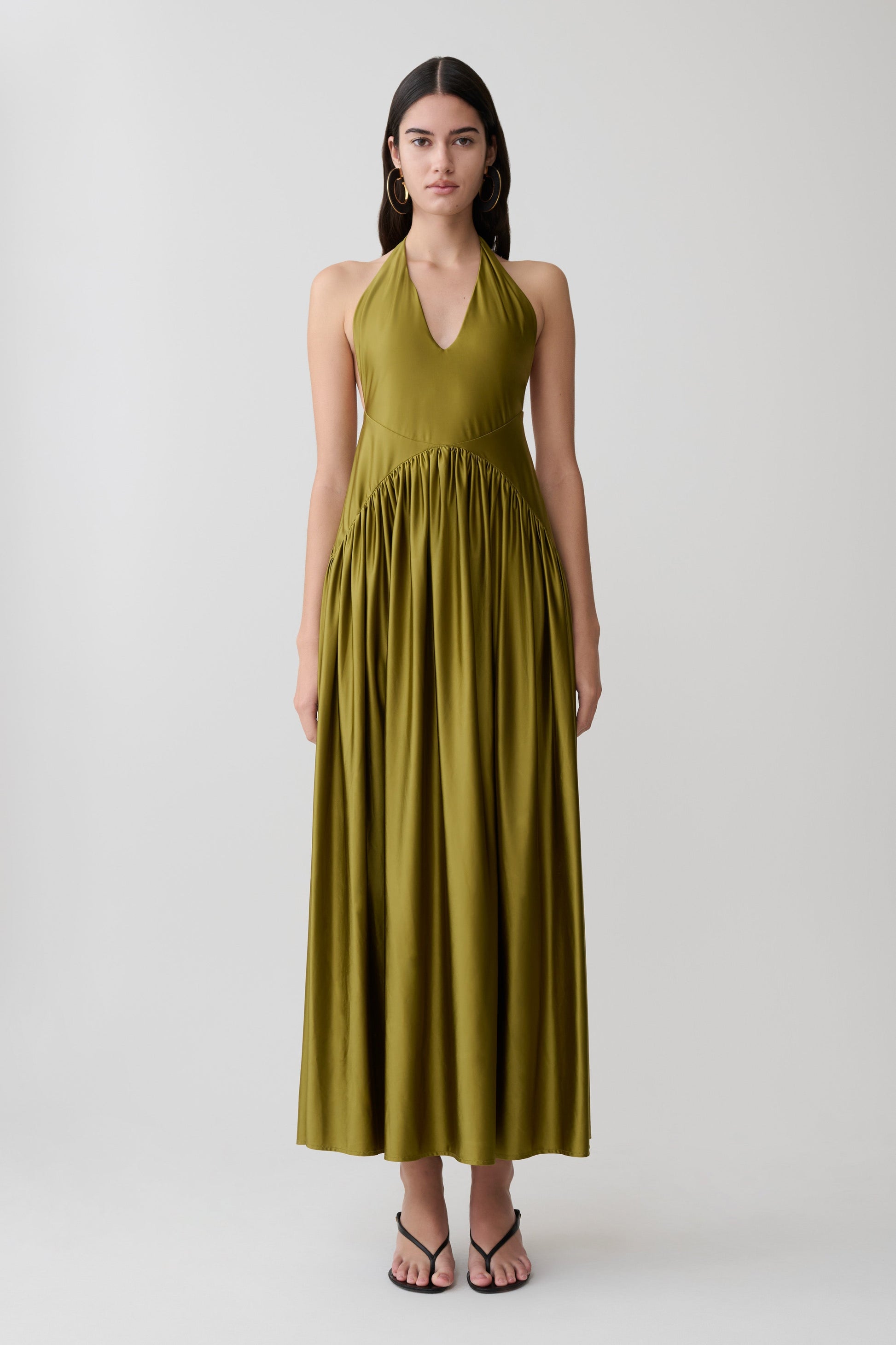 Woman wearing a green halter maxi dress.
