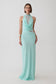 A woman modeling a sleeveless mint green maxi dress with a high mock neck, draped cowl neckline, sheer lace inserts at the bust and waist, and a flowing skirt, photographed against a light gray studio background.