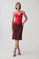 A model wearing a two-piece lace set consisting of a bright red lace camisole top and a dark burgundy lace midi skirt, paired with strappy high-heeled sandals against a light gray studio background.