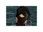 Image of woman in black ruched maxi dress with cut out.