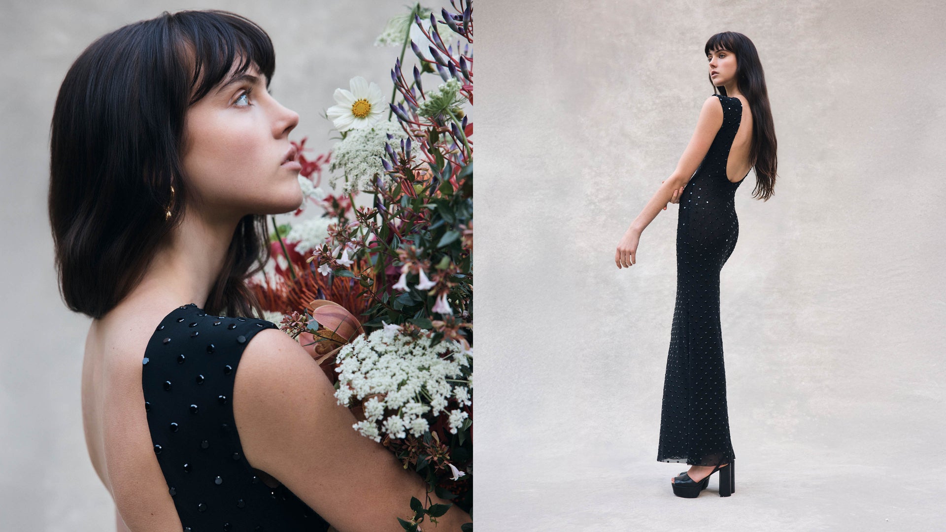 Woman in a black dress standing next to a floral arrangement on a neutral background.