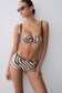 Woman wearing a zebra print bikini top with matching mini shorts.