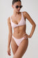 A model wearing a light pink two-piece bikini with a scoop neck top and matching high-cut bottoms, styled with round sunglasses against a plain light gray background.